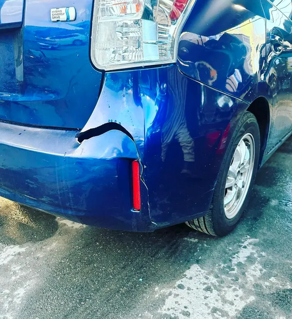 Professional auto body collision repair work being performed on damaged vehicle